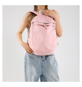 Vista detallada de una mochila de nailon rosa claro con correas ajustables en modelo