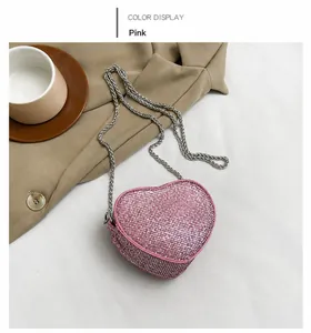 Macro detail of heart-shaped mini bag with pink rhinestones and silver chain strap