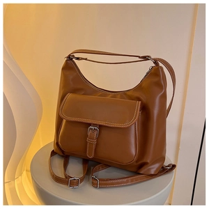 Détail du sac à dos en cuir marron caramel avec surpiqûres contrastées et boucle métal