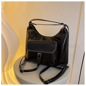 Détail du sac à dos rétro noir avec surpiqûres blanches et boucle métallique
