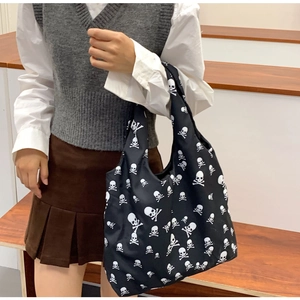 Close-up of black bucket bag with white skull print and large interior storage