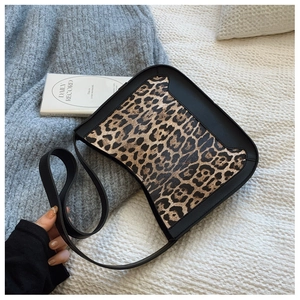 Detail of leopard print fabric and black leather trim on a vintage hobo shoulder bag