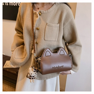 Détail du sac à main marron oreilles de chat avec panneaux léopard et breloque peluche