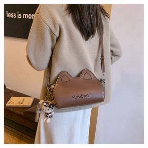 Détail d'un sac en cuir marron à oreilles de chat avec panneaux léopard et charm chat mignon