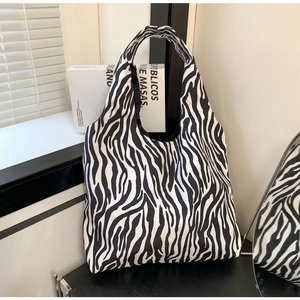 Detail of high-capacity tote bag featuring zebra print fabric and integrated handle design