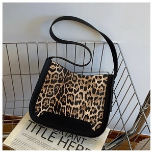 Detail view of leopard print texture and black leather stitching on a small square bag
