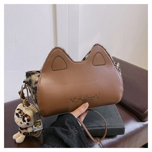 Détail d'un sac à main en cuir marron avec oreilles de chat et motifs léopard