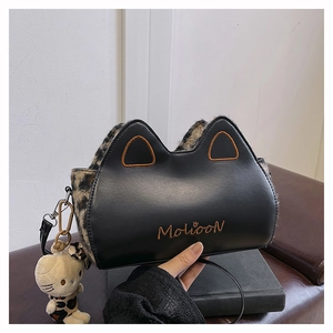 Détail d'un sac à main en cuir noir avec fourrure léopard, oreilles de chat et peluche