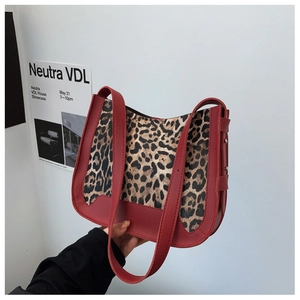 Detail showing red leather and leopard print patchwork with silver rivets on shoulder bag