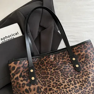 Primer plano de un bolso tote con estampado de leopardo y asas negras elegantes