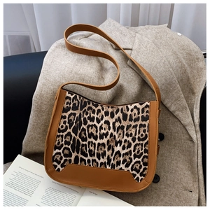 Close-up of leopard print baguette bag on a grey wool blazer with vintage aesthetic