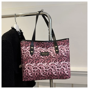 Detail der pinkfarbenen Totebag mit Leopardenmuster, Ledergriffen und Goldnieten-Akzenten