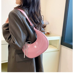 Close-up of pink crescent underarm bag with Fashion logo and silver bead chain detail