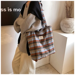 Detail der Retro-Karo-Tasche aus Wolle in Orange und Blau mit weißem Etikett vorne