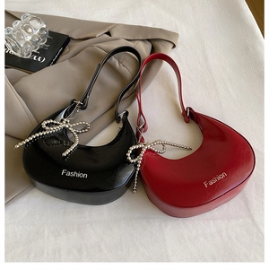 Detail of vintage crescent handbags in black and dark red with pearl bow charms