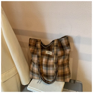Dettaglio della borsa tote in lana a quadri vintage con trama tessuta ed etichetta in tessuto