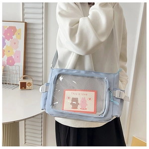 Dettaglio della borsa a tracolla celeste con finestra in PVC e simpatica cartolina di orso