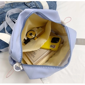 Vista dall'alto dell'interno della borsa in nylon blu con fodera gialla e spazio ampio