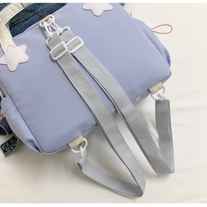 Dettaglio borsa in nylon lilla con tracolle grigie e toppa a forma di stella bianca