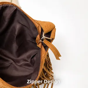 Close-up of the smooth zipper closure and gold hardware on the brown suede fringe bag