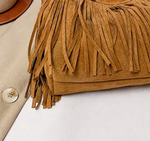 Close-up of brown suede hobo bag featuring dense fringe tassels and precision stitching