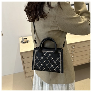 Détail du sac à main noir matelassé avec coutures en cœur et bordure en dents de scie