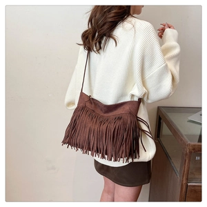 Detailed view of brown faux suede hobo bag with long tassels and shoulder strap