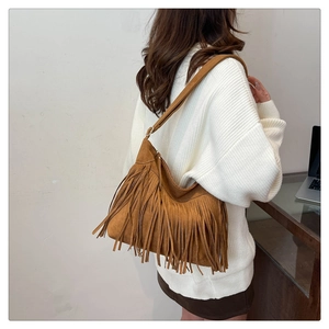 Detail of bohemian brown suede shoulder bag with long fringes shown on a model