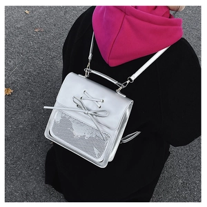 Silver leather backpack detail featuring lace-up bow design and mesh pocket on back
