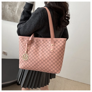 Detail of pink tote bag with M letter prints and gold metallic charm accessory