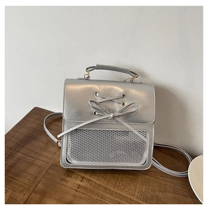 Detail of silver PU backpack showing lace-up bow design and front mesh pocket