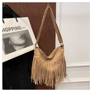 Detail shot of brown suede tote bag featuring bohemian long tassels and moon shape