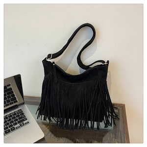 Close-up of black fringe tassel shoulder bag in soft faux suede with metal buckle