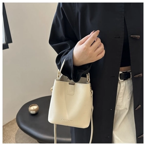Vue détaillée du sac seau en cuir crème avec logo FASHION embossé et bandoulière