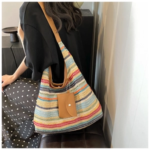 Detail of colorful woven shoulder bag with brown leather strap and matching mini pouch