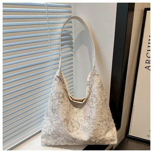 Détail de la broderie papillon 3D et de la bandoulière en cuir lisse sur ce sac fourre-tout