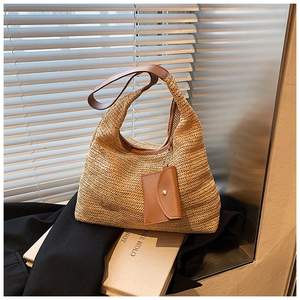 Close-up of woven straw handbag texture with brown leather strap and coin purse
