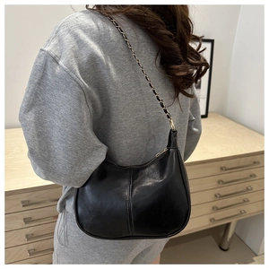 Détail du sac hobo en similicuir noir avec bandoulière chaîne et surpiqûres