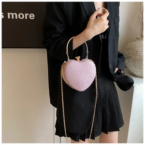 Rosafarbene herzförmige Glitzer-Clutch mit goldenem Metallgriff und feiner Kette