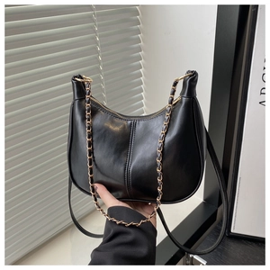 Détail du sac demi-lune noir avec chaîne dorée et double couture verticale élégante