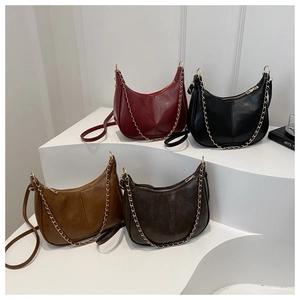 Vue détaillée des sacs demi-lune en rouge, noir et marron avec chaînes en métal