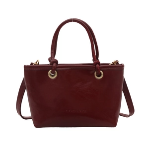 Fashion burgundy bucket bag in glossy leather with gold hardware and top handles