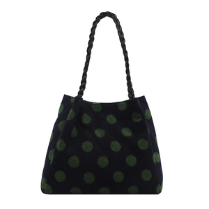 Large woolen tote bag with green polka dots and black woven handles on white background