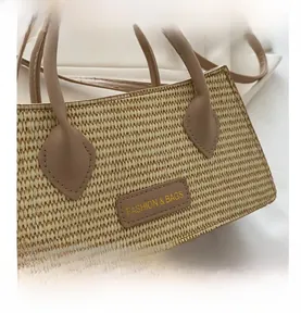 Close-up of woven beige handbag featuring a premium leather patch and neat stitching detail
