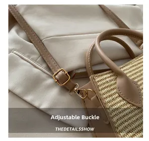Close-up of straw woven handbag featuring adjustable leather strap and metal buckle