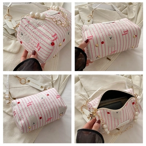 Detailed views of pink striped cylinder bag featuring cartoon dog print and pearl handle