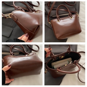 Détails du sac vintage marron avec logo FASHION, poignée nouée et ornements dorés