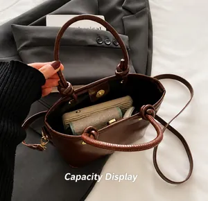 Vue intérieure montrant la grande capacité d'un sac rétro en cuir marron avec boucle aimantée