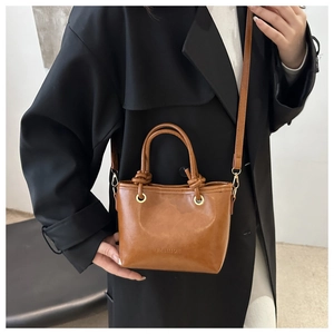 Détail du sac en cuir PU marron avec poignée nouée et œillet métallique doré chic