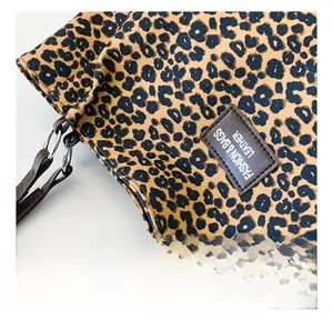 Close-up of leopard print canvas tote bag with a brown leather fashion brand tag